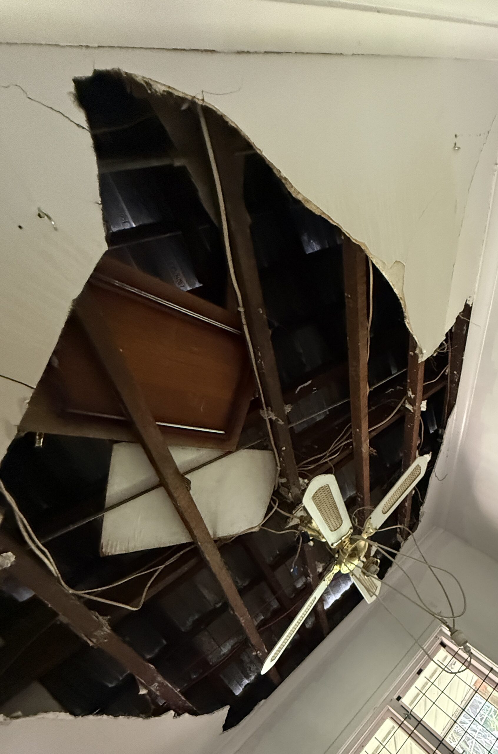 Water-damaged ceiling collapsed due to blocked gutters. Exposed rafters and wet insulation highlight the risk of neglecting regular gutter cleaning in Perth.